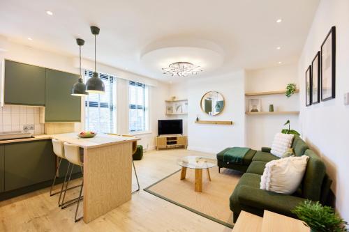 a kitchen and living room with a couch and a table at Aura - Elegant Retreat in Prime Leeds Location! in Headingley