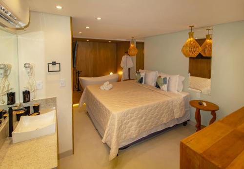 a bedroom with a large bed and a bathroom at Terra Bella Pousada in Morro de São Paulo