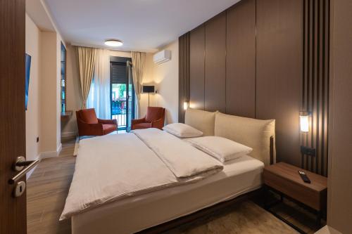 a bedroom with a large white bed and chairs at Nordic Nest Kolašin in Kolašin
