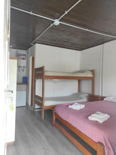 a bedroom with two bunk beds with purple sheets at Cabañas del Rio in Gualeguaychú