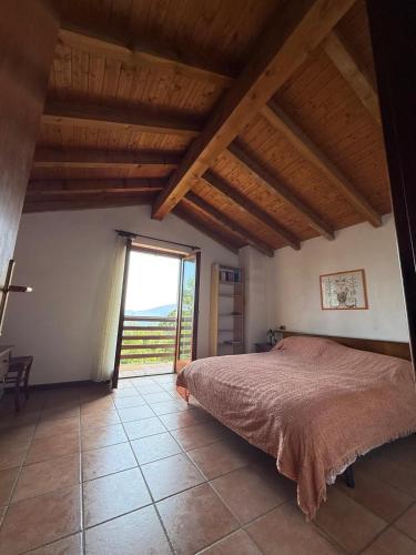 a bedroom with a bed and a large window at Baita del Silenzio in Miazzina