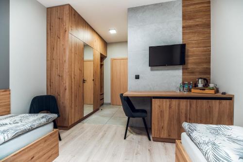 una camera d'albergo con scrivania e TV di Hotel MADRID a Krzemionka