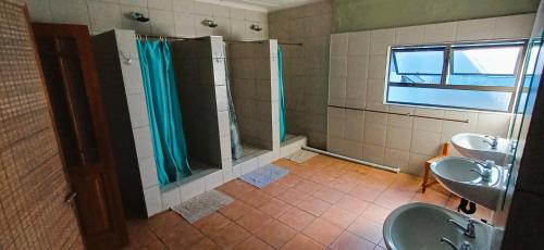 a bathroom with two sinks and a shower at Oceanic Flashpackers accommodation in East London