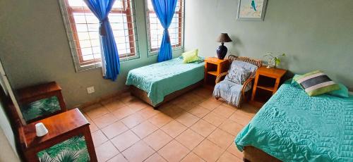 a bedroom with two beds and a chair and a window at Oceanic Flashpackers accommodation in East London