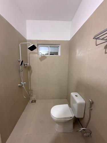 a bathroom with a toilet and a window at Lemon Lodge Nungwi in Nungwi