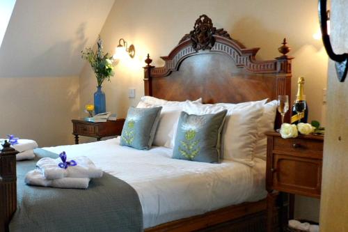 a bedroom with a large bed with a wooden headboard at Knightcote Farm Cottages in Gaydon