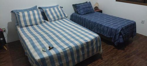 two beds sitting next to each other in a room at Quarto Suíte Pitanga in Atibaia