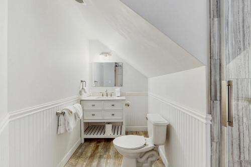 a white bathroom with a toilet and a sink at Stargazing Daydreamer in Arlington