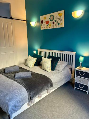 a bedroom with two beds and a blue wall at Queens Gate in Portsmouth