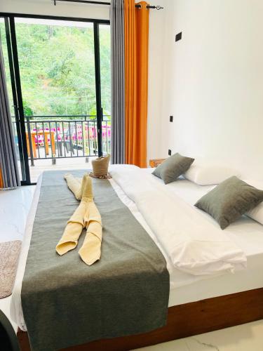 a large bed with two pairs of yellow ties on it at Ella 78 Resort in Ella