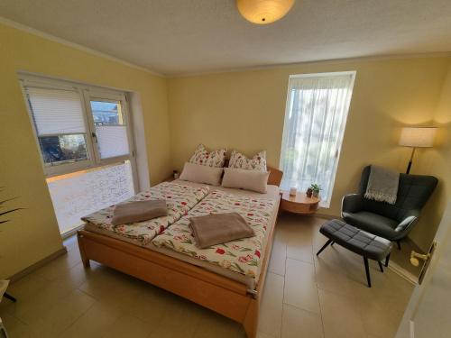 a bedroom with a bed with a chair and a window at Ferienwohnung Bachklang Oberprechtal in Elzach