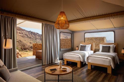 a bedroom with two beds and a living room with a couch at Moon Retreat by Sharjah Collection in Sharjah