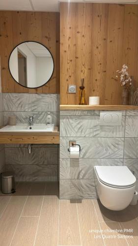 a bathroom with a toilet and a sink and a mirror at Hôtel Les Quatre Saisons in Dullin