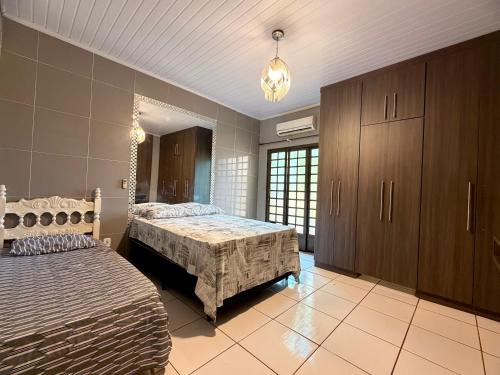 a large bedroom with two beds and a dresser at Pousada Complexo Girassol in Dourados