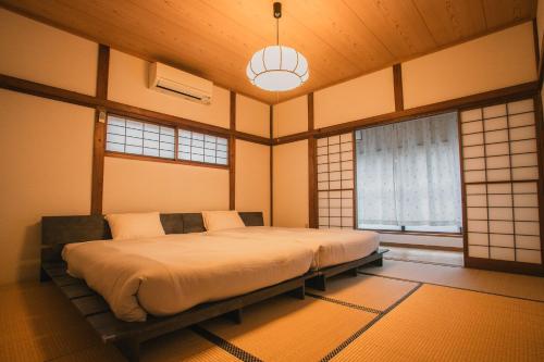a bedroom with a large bed in a room with windows at 網代温泉源泉かけ流し 阿治古の宿 in Atami