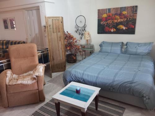 a bedroom with a bed and a chair and a table at Στουντιο στο Πανοραμα in Thessaloniki
