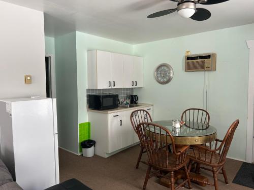 una cucina con tavolo e sedie e una cucina con frigorifero di Mountain View Motel a Barrys Bay