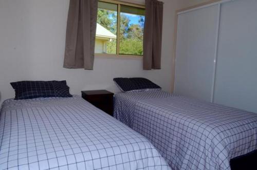 a bedroom with two beds and a window at Lake Barra Cottages in Downsfield