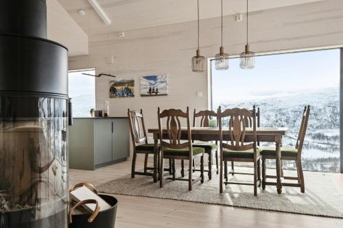 a kitchen and dining room with a table and chairs at New Cabin With Panoramic Views At Hardangervidda in Eidfjord