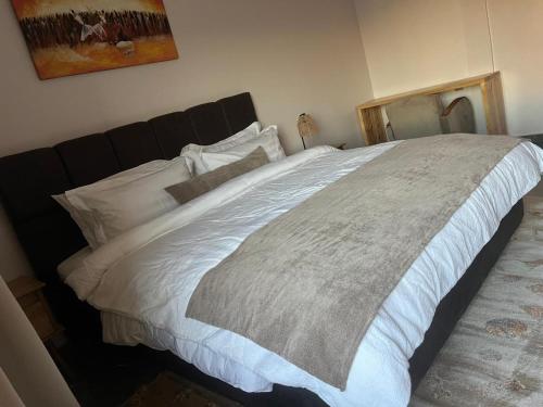 a bedroom with a large bed with white sheets at HJ Appartements Haut Standing in Nouakchott