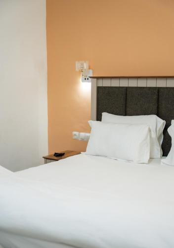 a bedroom with a bed with white pillows at Immeuble Avenue 30 Juin - Lubumbashi in Lubumbashi