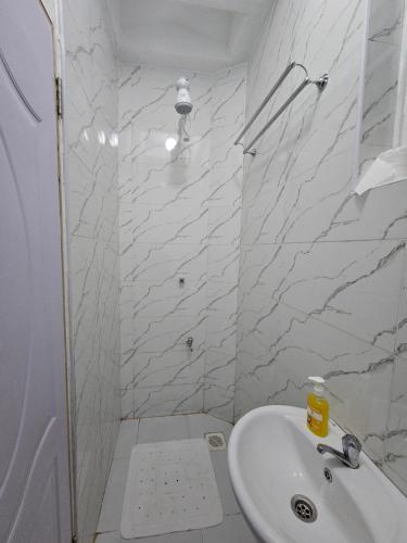 a white bathroom with a sink and a shower at Upscale homes in Ongata Rongai 