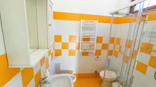 a bathroom with orange and white stripes on the wall at Villa Mary - Apartment in Trani