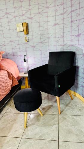 a black chair and a stool in a room at Monoambiente Eldorado 2 in Eldorado