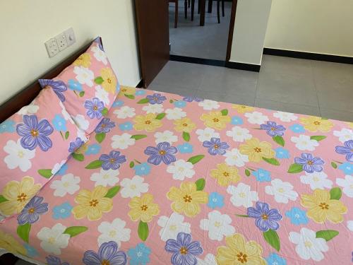 a bed with a flower pattern on it with a pillow at Peacock Residence in Dickwella