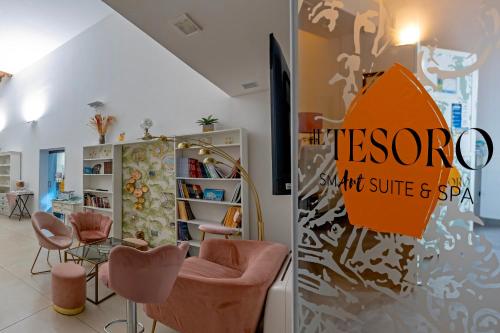 a room with pink chairs and an orange umbrella at Il Tesoro Smart Suite & SPA in Naples