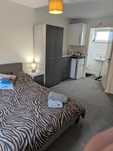 a bedroom with a zebra print bed and a kitchen at Special Offer CORBY En- Suite Double Room Near Rockingham Min 4 night stay for Couples or Single person Available in Shared property & fully equipped in Rockingham
