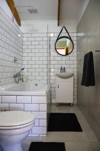 a bathroom with a toilet and a tub and a sink at Stonehaven Clarens in Clarens