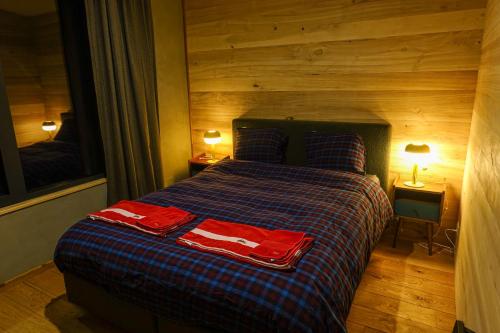 a bedroom with a bed with two red towels on it at Chez Oreste - Escapade à 2 avec sauna et jardin clos in Aywaille