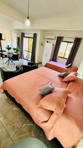 a large bedroom with a large orange bed with pillows at Monoambiente Eldorado 6 in Eldorado