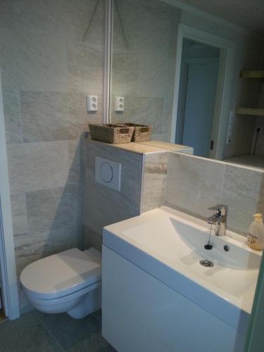 a bathroom with a white sink and a toilet at Moderne feriehus in Laupstad