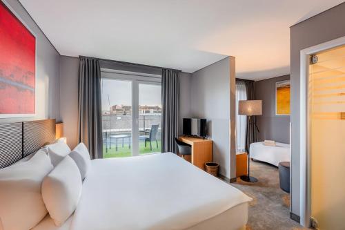 a hotel room with a bed and a large window at Hotel Museum Budapest in Budapest