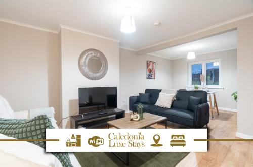 a living room with a couch and a tv at Kingswood in Bishopton