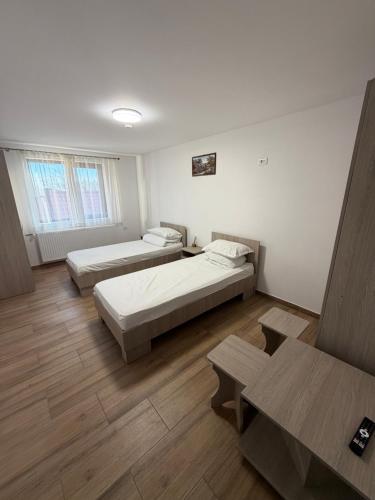 a room with two beds and two tables in it at Casa Drăghici in Nucet