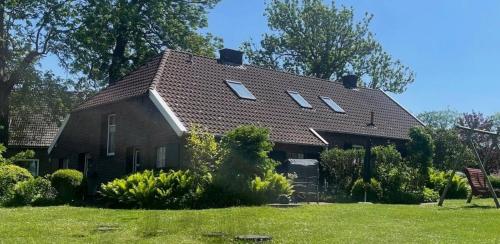 a brown house with a gambrel roof at Landhaus up de Warft - Mühlenblick in Werdum