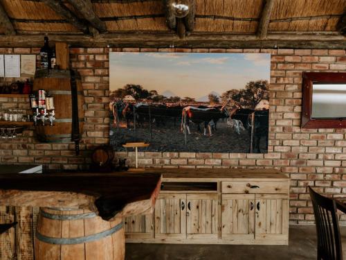 un muro con un dipinto di mucche in un campo di Cascata Lodge a Outjo
