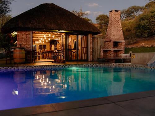 una casa con piscina e camino di Cascata Lodge a Outjo