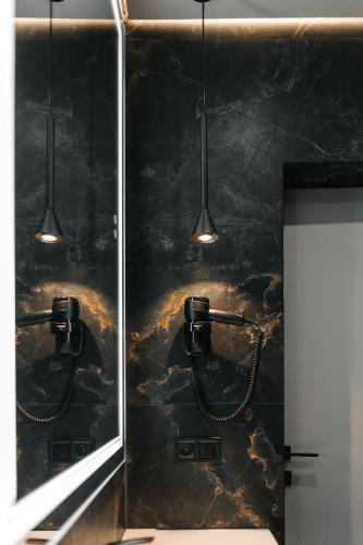 a bathroom with a black marble wall with lights at Relax Resort in Reshetilovskiy Kut
