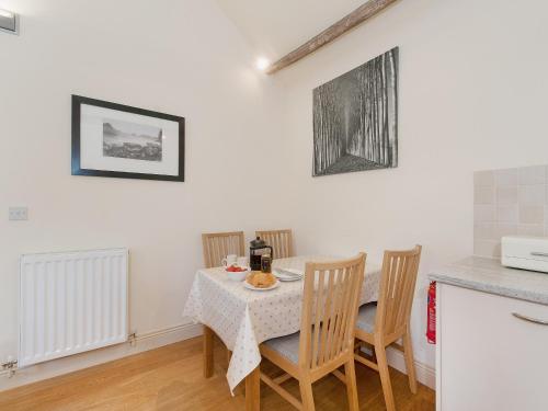a dining room with a table with chairs and a kitchen at Hurworth - 25565 in Knapton