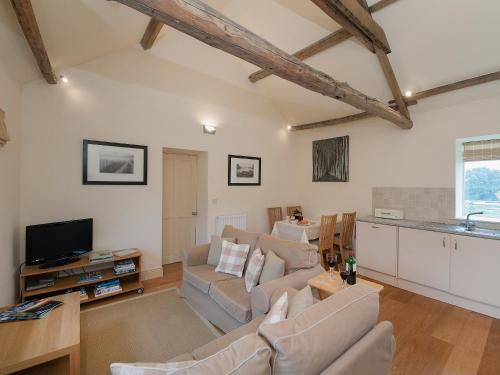a living room with a couch and a tv at Hurworth - 25565 in Knapton