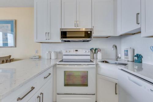 a white kitchen with a stove and a microwave at 0709 Seaside Serenade by Atlantic Towers in Carolina Beach