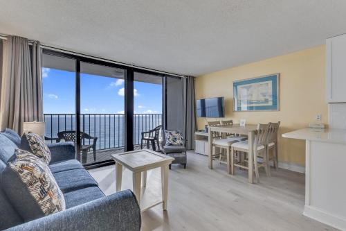 a living room with a couch and a table at 0709 Seaside Serenade by Atlantic Towers in Carolina Beach