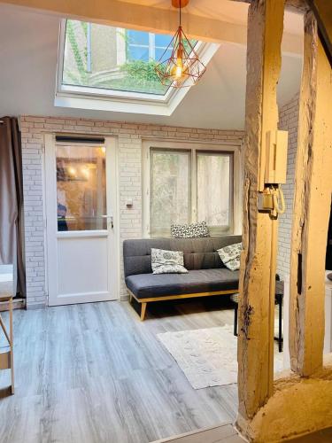 a living room with a couch and a window at Charmante maison triplexe avec jardinet in Orléans