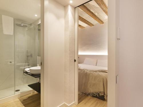 a bathroom with a bed and a sink and a shower at Decô Apartments Barcelona-Born Apt. in Barcelona