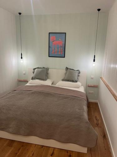 a bedroom with a large bed with two pillows at Moderne Apartments in Wicker in Flörsheim am Main