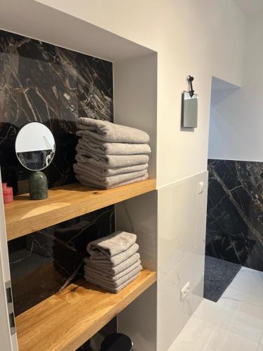 a pile of towels on a shelf in a bathroom at Moderne Apartments in Wicker in Flörsheim am Main